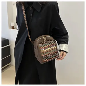 Close-up of ethnic style crossbody bag with zigzag pattern and wide woven strap