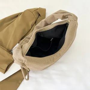 Detail of khaki corduroy hobo bag showing inner lining and smooth gold zipper closure