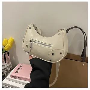 Close-up of cream white crackle leather handbag with silver rivets and zipper detail