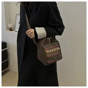 Close-up of bohemian style crossbody bag with wave pattern weave and wide strap