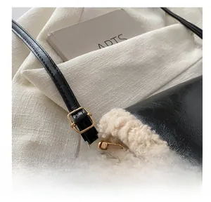 Detail of adjustable golden metal buckle on black leather shoulder strap with fur trim