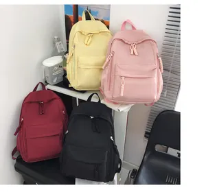 Detail view of four colorful water-resistant nylon backpacks in a modern lifestyle setting
