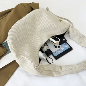 Interior storage capacity of cream corduroy shoulder bag with iPad and umbrella