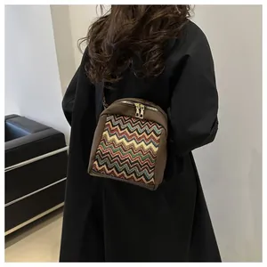Close-up of bohemian style shoulder bag with colorful woven pattern on model