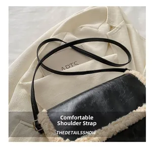Detail of comfortable black leather shoulder strap with gold buckle on plush bag