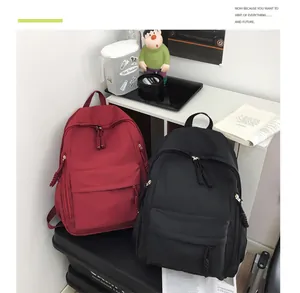 Detail of red and black school backpacks showing multi-pocket design and woven pullers