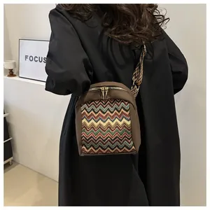 Detailed view of embroidery patterns and dual metal zippers on ethnic crossbody bag