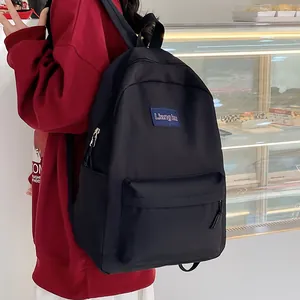 Minimalistischer schwarzer Nylon-Rucksack mit hohem Fassungsvermögen am Modell gezeigt