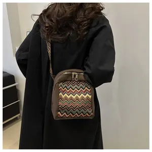 Close-up of ethnic style crossbody bag with zigzag pattern and wide jacquard strap