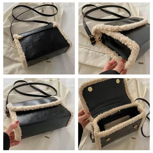 Detail view of black faux leather crossbody bag with beige faux fur trim and magnetic closure