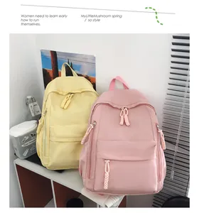 Detail of minimalist nylon backpacks in yellow and pink with woven rope zipper pulls