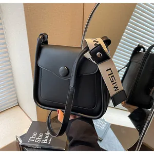 Dettaglio della borsa a tracolla nera opaca con cinturino MISU e riflessi eleganti nello specchio