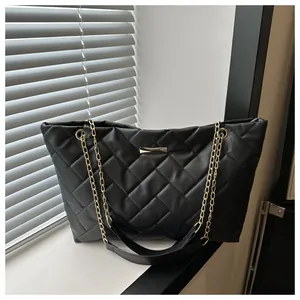 Close-up of black quilted tote bag featuring a gold chain strap and rhombic texture