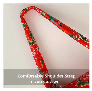 Detail of the red floral satin shoulder strap with traditional peony embroidery pattern