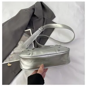 Detailed view of silver metallic shoulder bag with stud accents and wrinkled faux leather