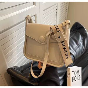 Detail of cream crossbody bag with matte faux leather finish and wide woven shoulder strap