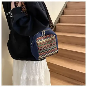 Detail of colorful zigzag woven pattern on a navy blue ethnic shoulder bag