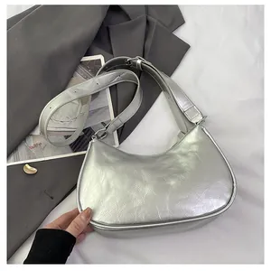 Detail of silver crescent shoulder bag with metallic wrinkled texture and adjustable strap