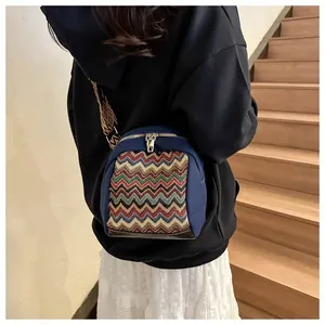 Close-up of mini canvas backpack featuring colorful zigzag weaving and ethnic wide strap