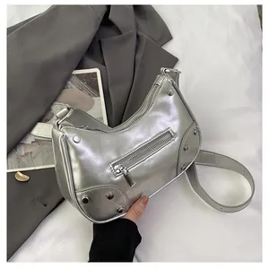 Close-up of silver rivet details and metallic wrinkled texture on the hobo bag