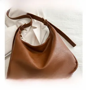 Detail of vintage brown textured faux leather hobo tote with gold hardware adjustments