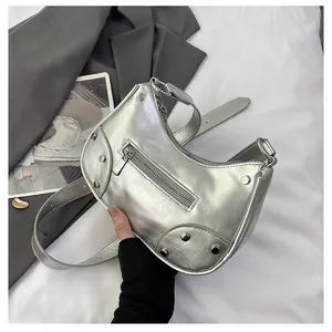 Detail of silver metallic dumpling bag with rivet accents and cracked leather texture