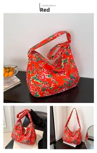Detail showing the red ethnic floral pattern and wide shoulder strap of the large tote bag
