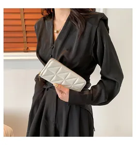 Détail d'une mini pochette blanche matelassée avec fermeture éclair et texture cuir