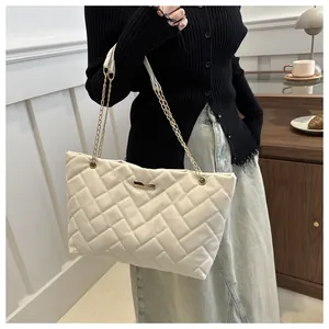 Chic beige quilted tote bag with gold chain strap shown on model for daily casual style