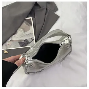 Detailed macro view of silver metallic bag with rivet studs and smooth zipper closure