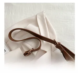 Detail of brown vintage leather bag showing metal buckle and stitching on shoulder strap