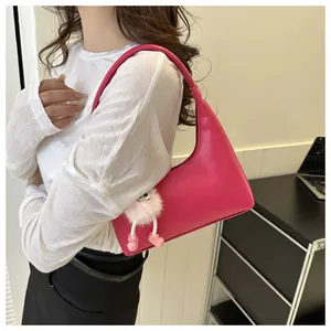 Dettaglio della borsa a cuscino rosa con un simpatico portachiavi a mostriciattolo