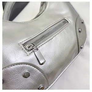 Detail of silver metallic dumpling bag featuring crackle texture and Y2K rivet accents
