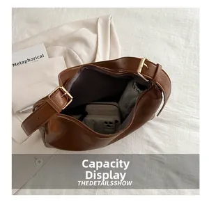 Capacity display of brown vintage hobo bag showing space for phone, wallet and umbrella