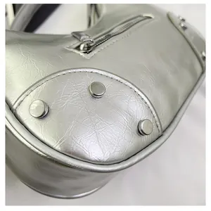 Detail of silver metallic handbag featuring vintage rivets and zipper texture