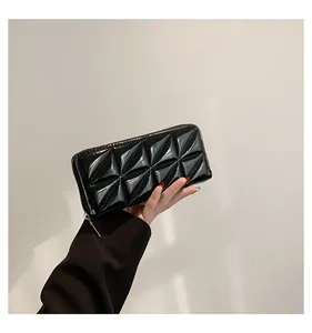 Vue détaillée du portefeuille en cuir verni noir avec motif géométrique 3D et zip doré