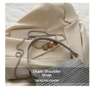 Detail shot of sparkling silver rhinestone evening bag with chain strap on beige blazer
