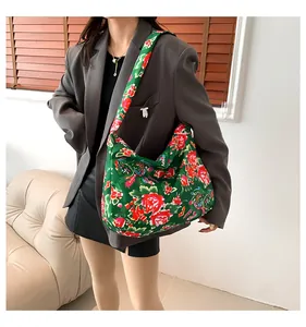 Close-up of ethnic style tote bag with traditional red peony patterns on green fabric