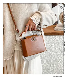 Dettaglio di borsa in pelle marrone con fibbia in metallo CB argento e tracolla sottile