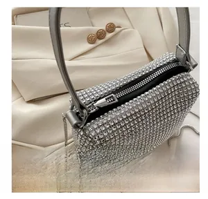 Detail showing high-quality smooth metal zipper and shiny rhinestones on silver handbag