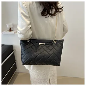 Close-up of black quilted PU leather tote bag with woven texture and gold chain strap