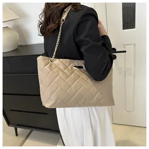 Detailed back view of a beige quilted tote bag with golden chain straps for women