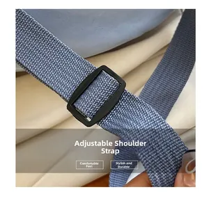 Detailed macro view of adjustable black buckle and woven nylon strap on crossbody bag