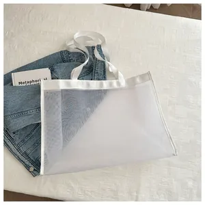 Detalle del bolso tote de malla blanca con textura de red fina y asas resistentes para playa