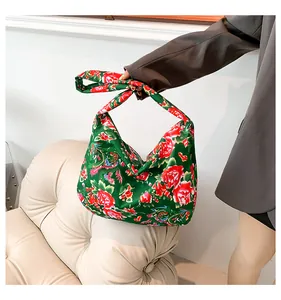 Detail of green floral satin tote bag with traditional Chinese peony pattern and knot handle