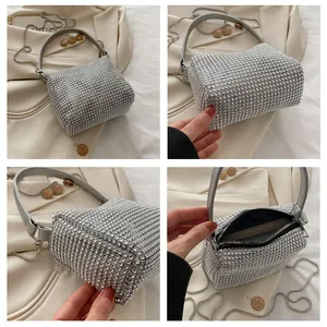 Detail view of silver rhinestone handbag with leather handles and metal chain strap