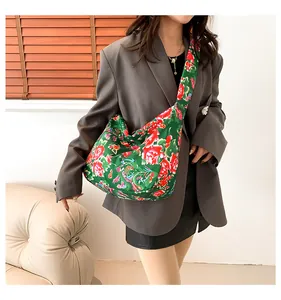 Close-up of ethnic tote bag with traditional Chinese red peony floral patterns on green fabric