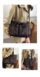 Detailed views of a black nylon tote bag featuring a red cherry pattern and multiple pockets