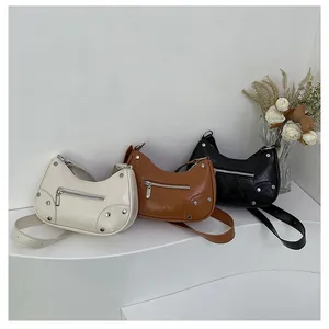 Detailed view of vintage rivet dumpling bags in off-white, brown, and black leather textures