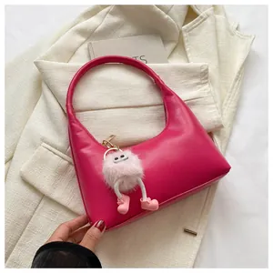 Dettaglio della borsa a mezzaluna rosso rosa in pelle PU con ciondolo a mostro